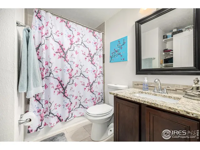 a bathroom with a granite countertop toilet sink and mirror