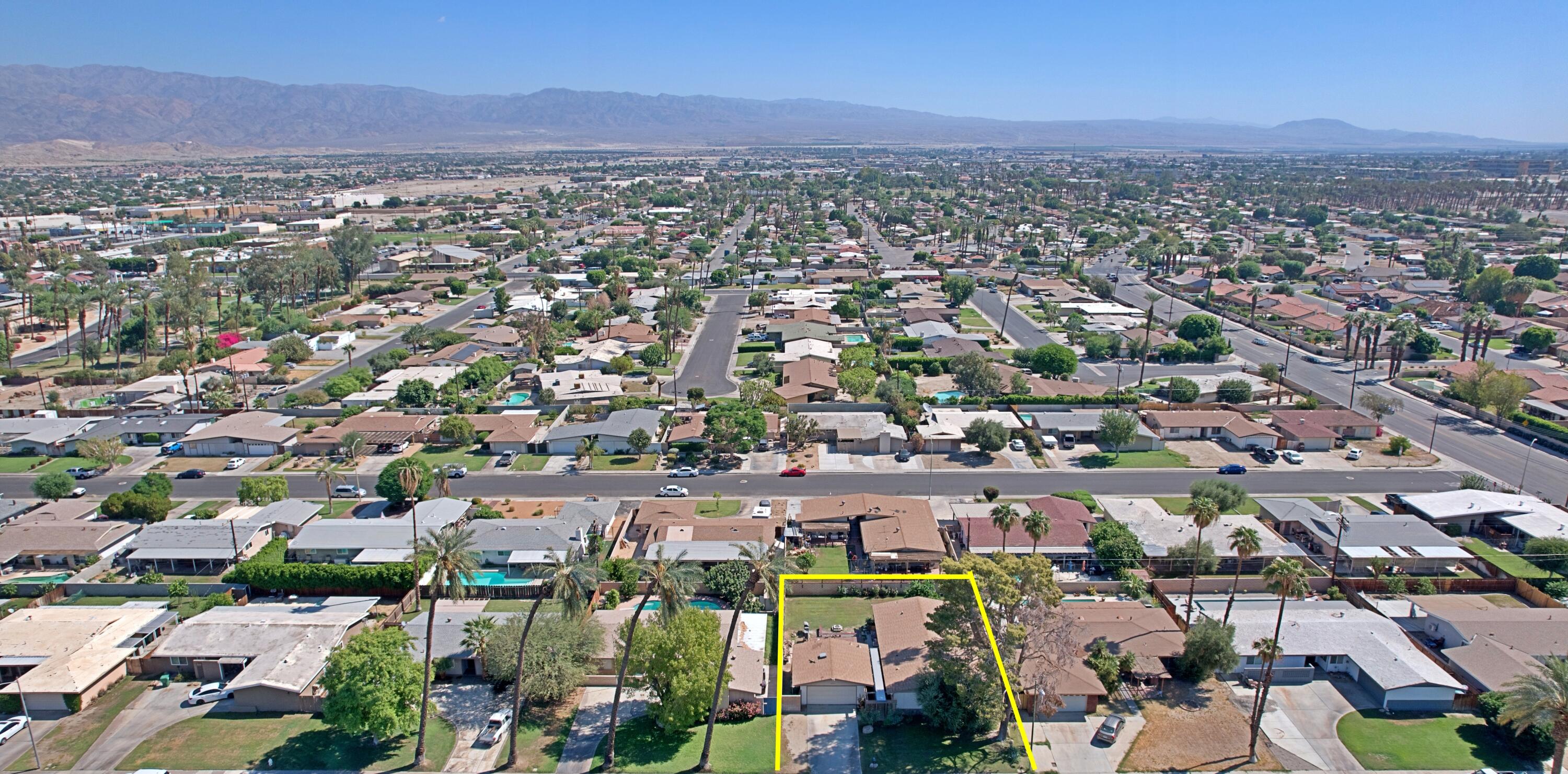 44840 Windsor Drive Indio, CA 92201 - Photo 3 of 26 an aerial view of a city with lots of residential buildings and mountain view in back