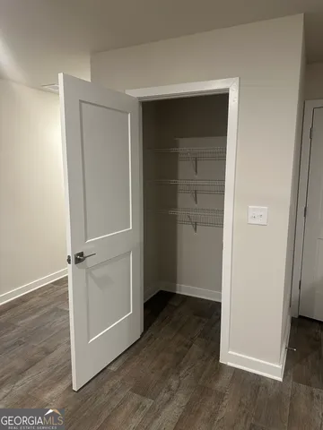 an empty room with wooden floor cabinet and closet