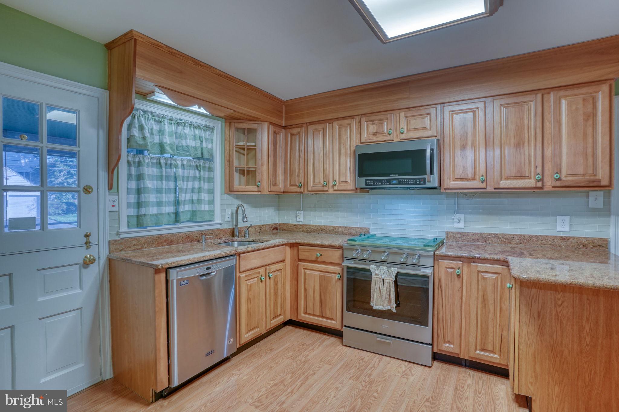 455 East Loockerman Street Dover, DE 19901 - Photo 14 of 55 a kitchen with stainless steel appliances granite countertop wooden cabinets and a stove top oven