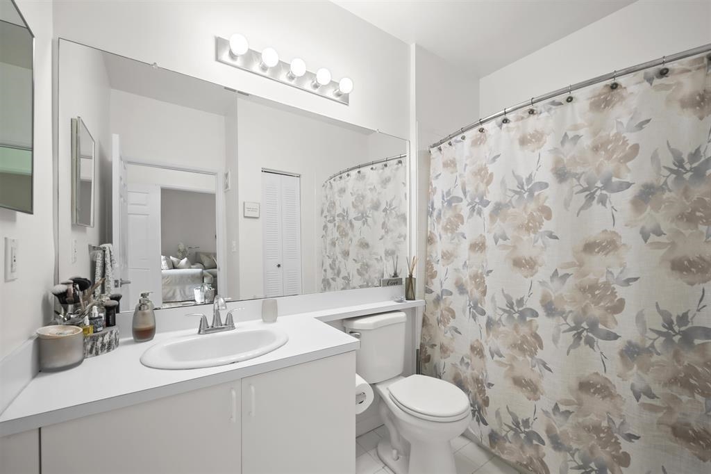 520 Florida Club Boulevard, Unit 104 St. Augustine, FL 32084 - Photo 11 of 20 a bathroom with a sink a toilet and a mirror