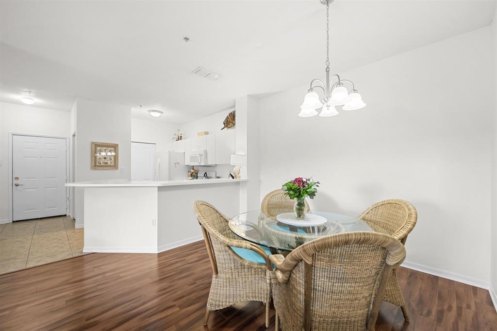 520 Florida Club Boulevard, Unit 104 St. Augustine, FL 32084 - Photo 9 of 20 a view of a dining room with furniture wooden floor and chandelier