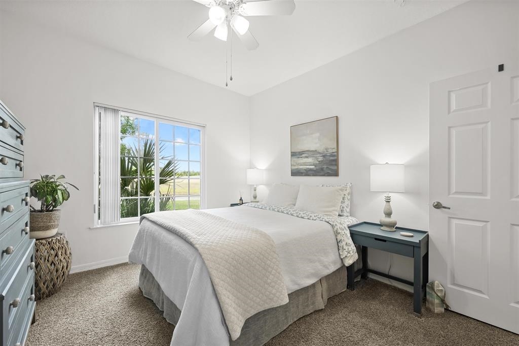 520 Florida Club Boulevard, Unit 104 St. Augustine, FL 32084 - Photo 10 of 20 a bedroom with a bed and a chandelier