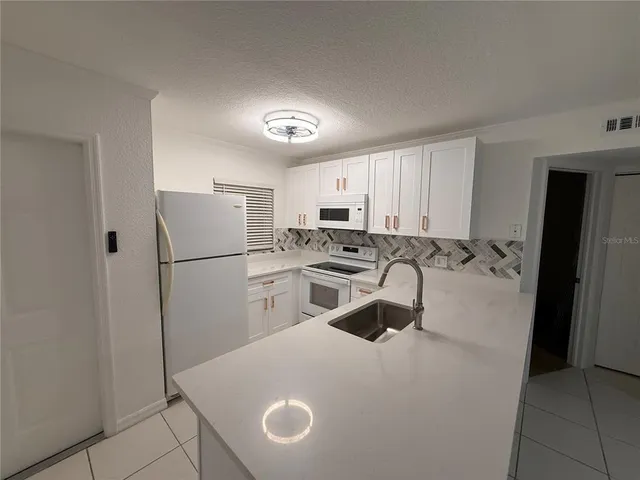 a kitchen with stainless steel appliances a sink and cabinets