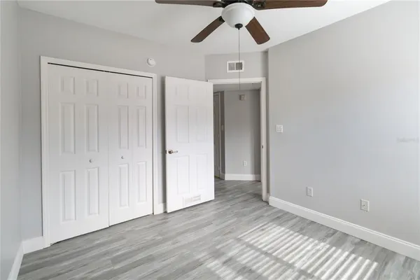 an empty room with wooden floor hallway and closet