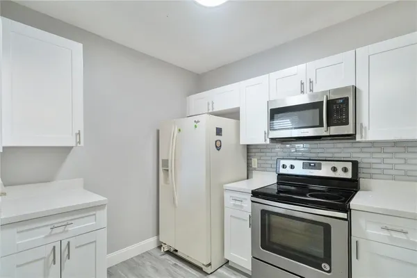 a kitchen with stainless steel appliances a stove a microwave and cabinets