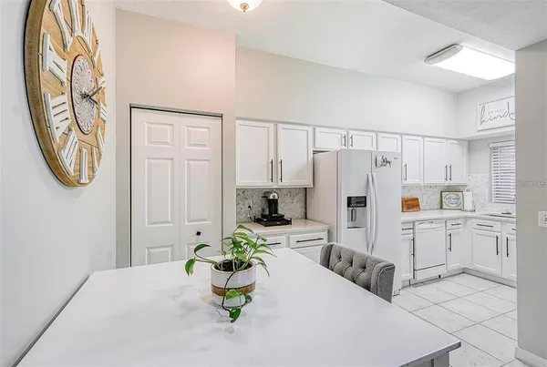 a white kitchen with white cabinets and stainless steel appliances