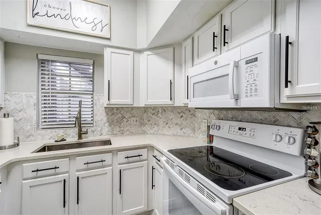 a kitchen with white cabinets and white appliances