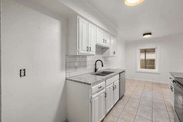a kitchen with granite countertop a sink cabinets and stainless steel appliances