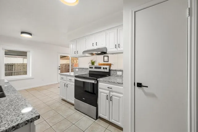a kitchen with granite countertop a stove and a sink