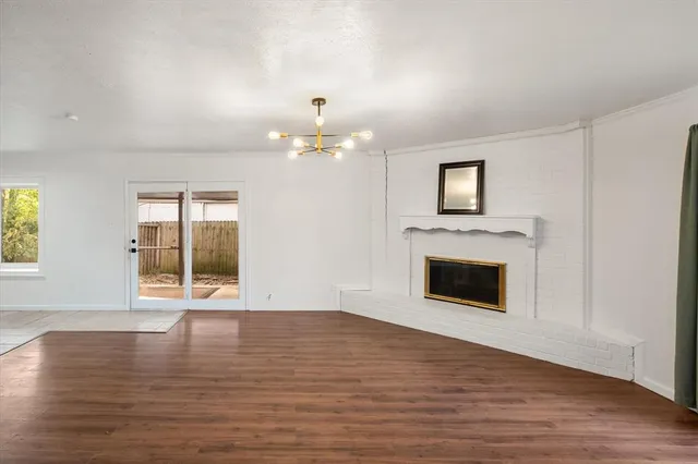 a view of empty room with wooden floor and fireplace