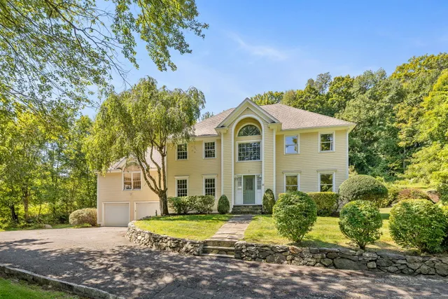 a view of white house with a yard and potted plants