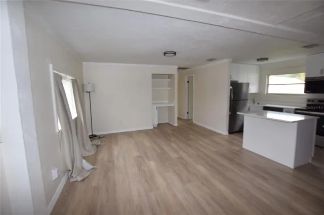 a view of kitchen with refrigerator stove and wooden floor