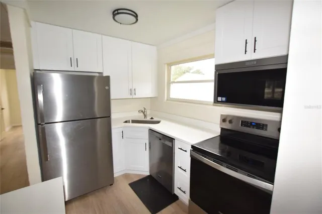 a kitchen with stainless steel appliances a refrigerator stove and microwave