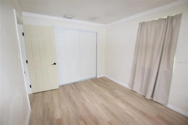 a view of an empty room with wooden floor