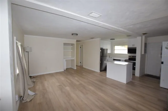 a view of kitchen with refrigerator stove and wooden floor