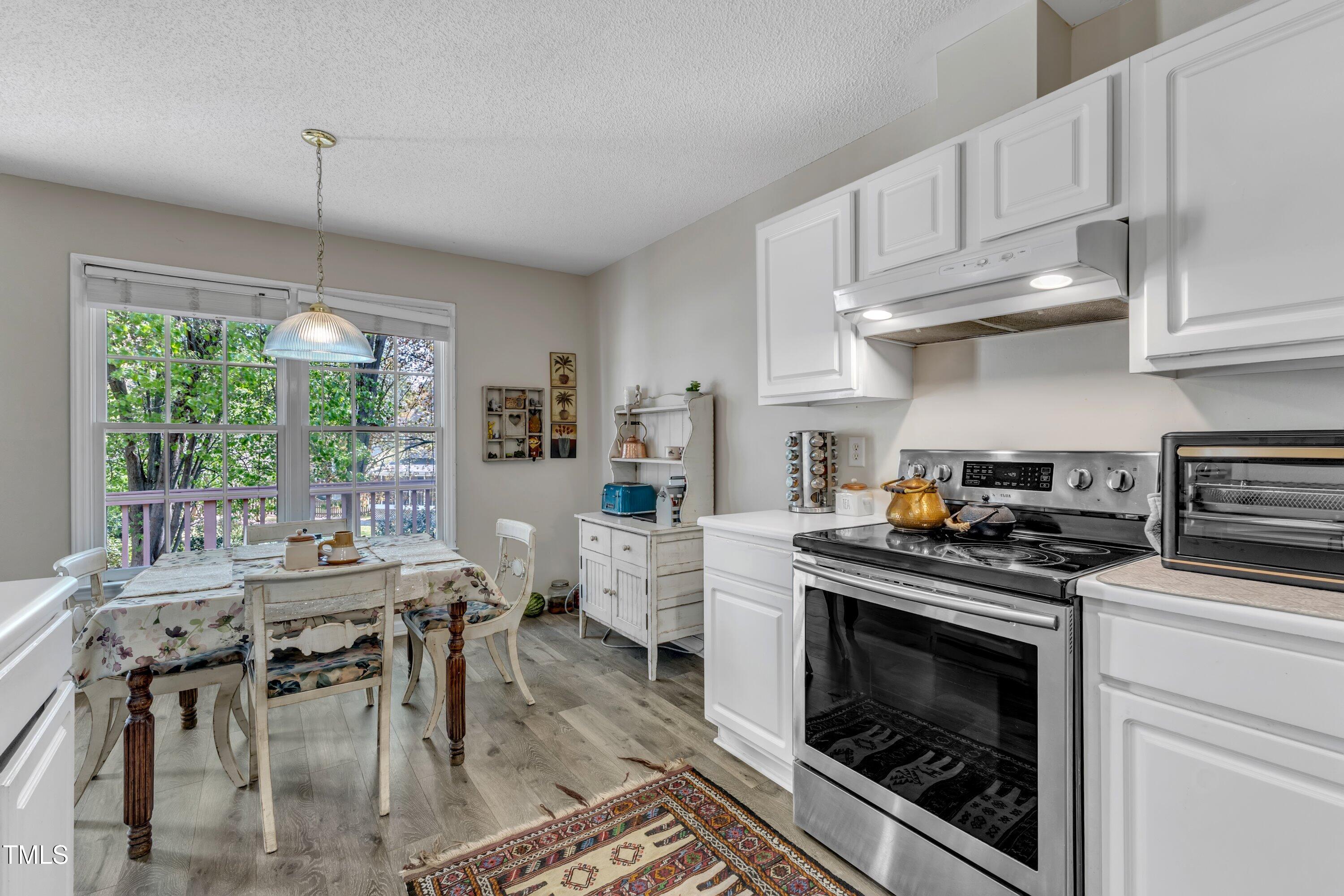 9512 Anson Grove Lane Raleigh, NC 27615 - Photo 13 of 39 a kitchen with stainless steel appliances kitchen island granite countertop a stove a sink and a refrigerator