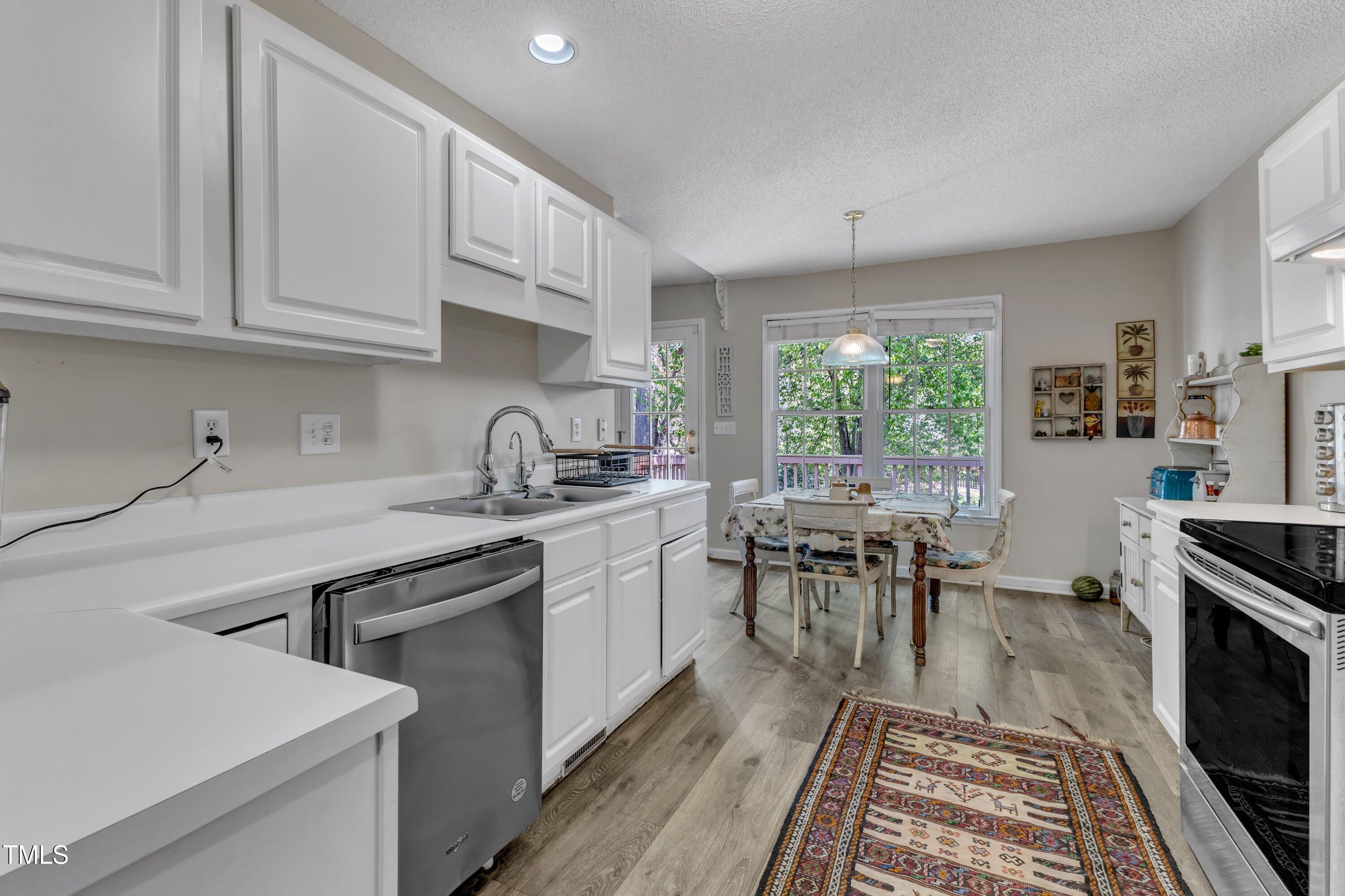 9512 Anson Grove Lane Raleigh, NC 27615 - Photo 14 of 39 a kitchen with sink cabinets and dining table chair