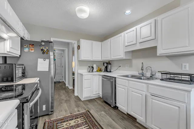a kitchen with cabinets stainless steel appliances and a sink