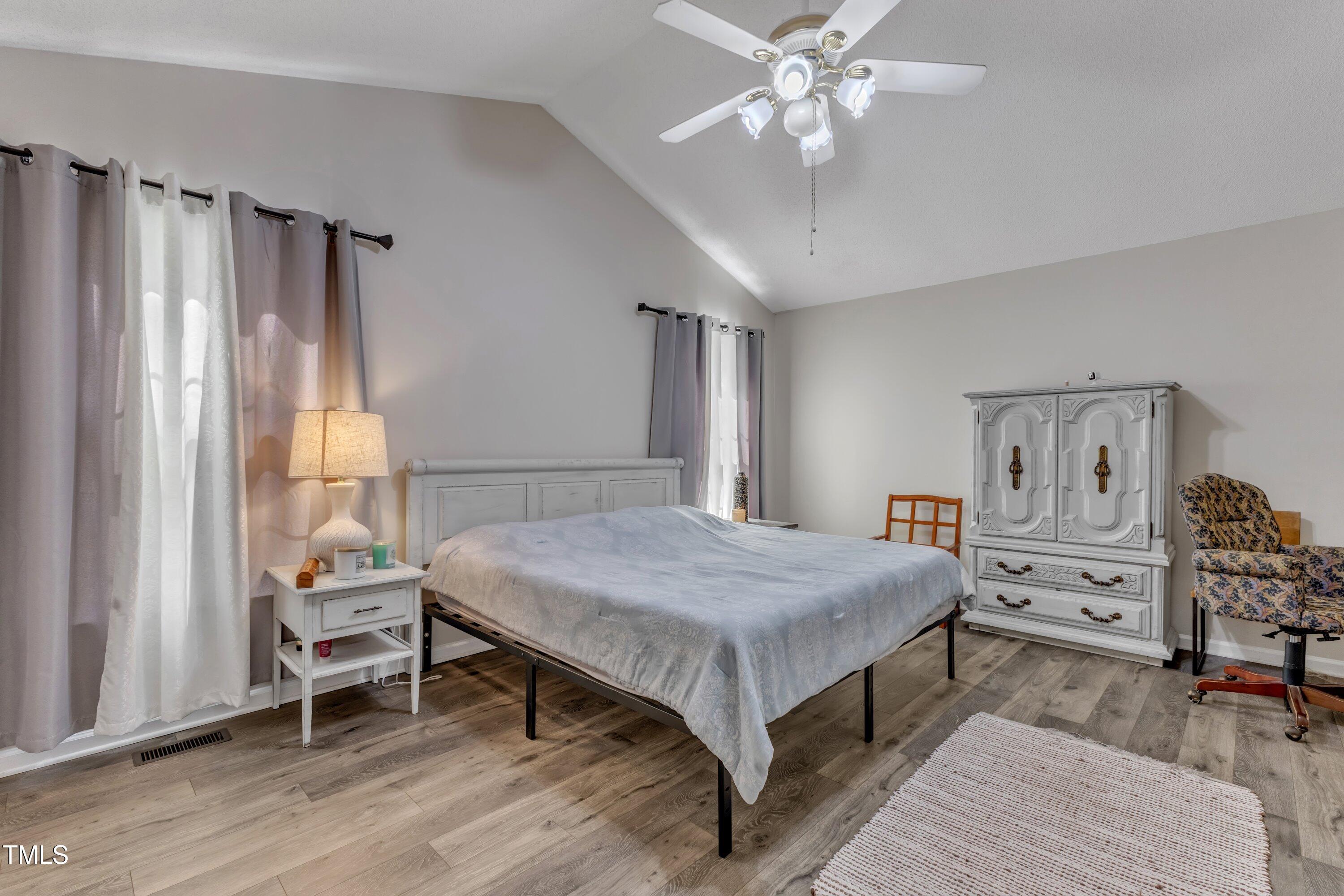 9512 Anson Grove Lane Raleigh, NC 27615 - Photo 18 of 39 a bedroom with a bed and a chandelier