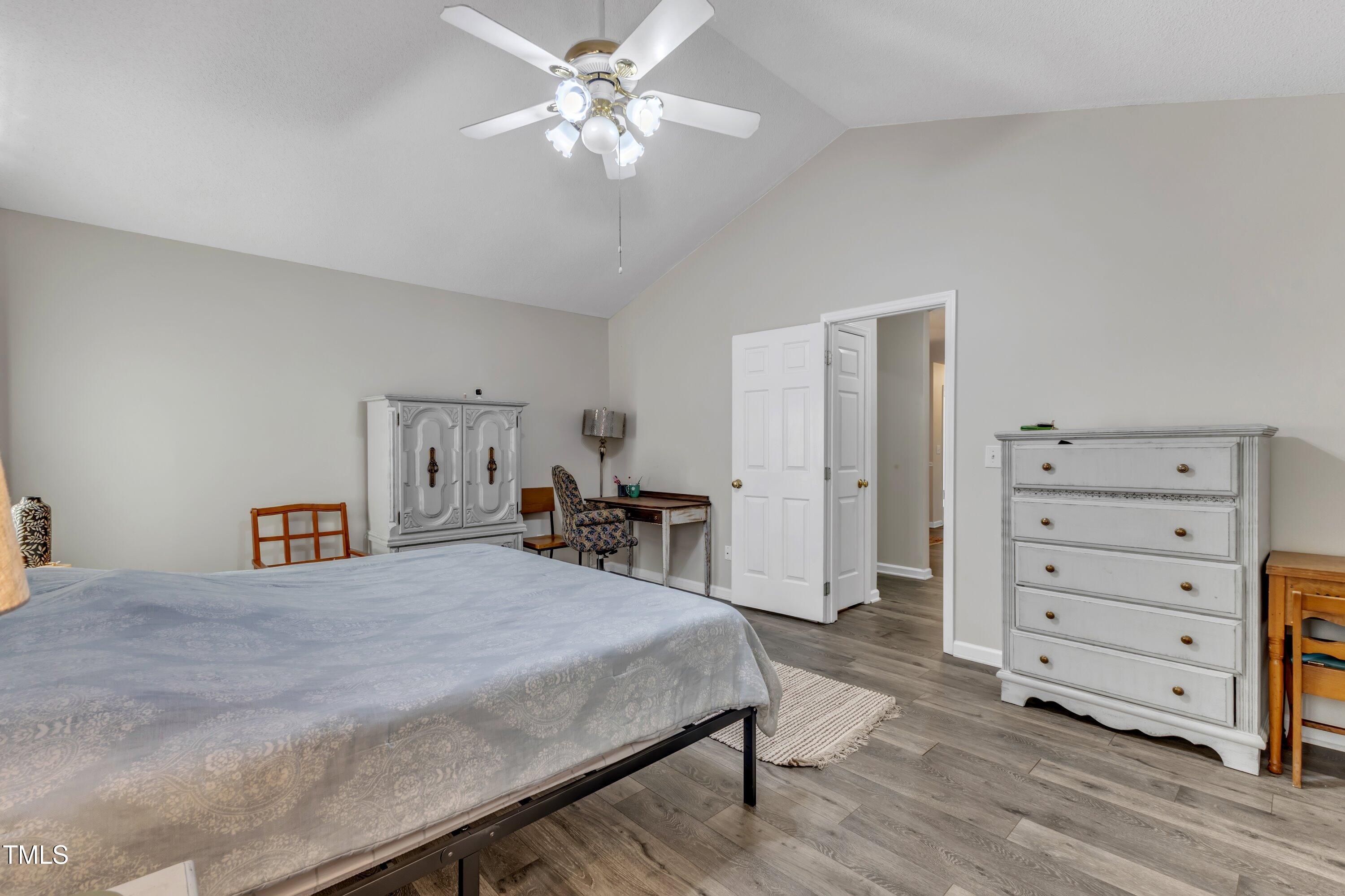 9512 Anson Grove Lane Raleigh, NC 27615 - Photo 20 of 39 a bedroom with a bed and a chandelier