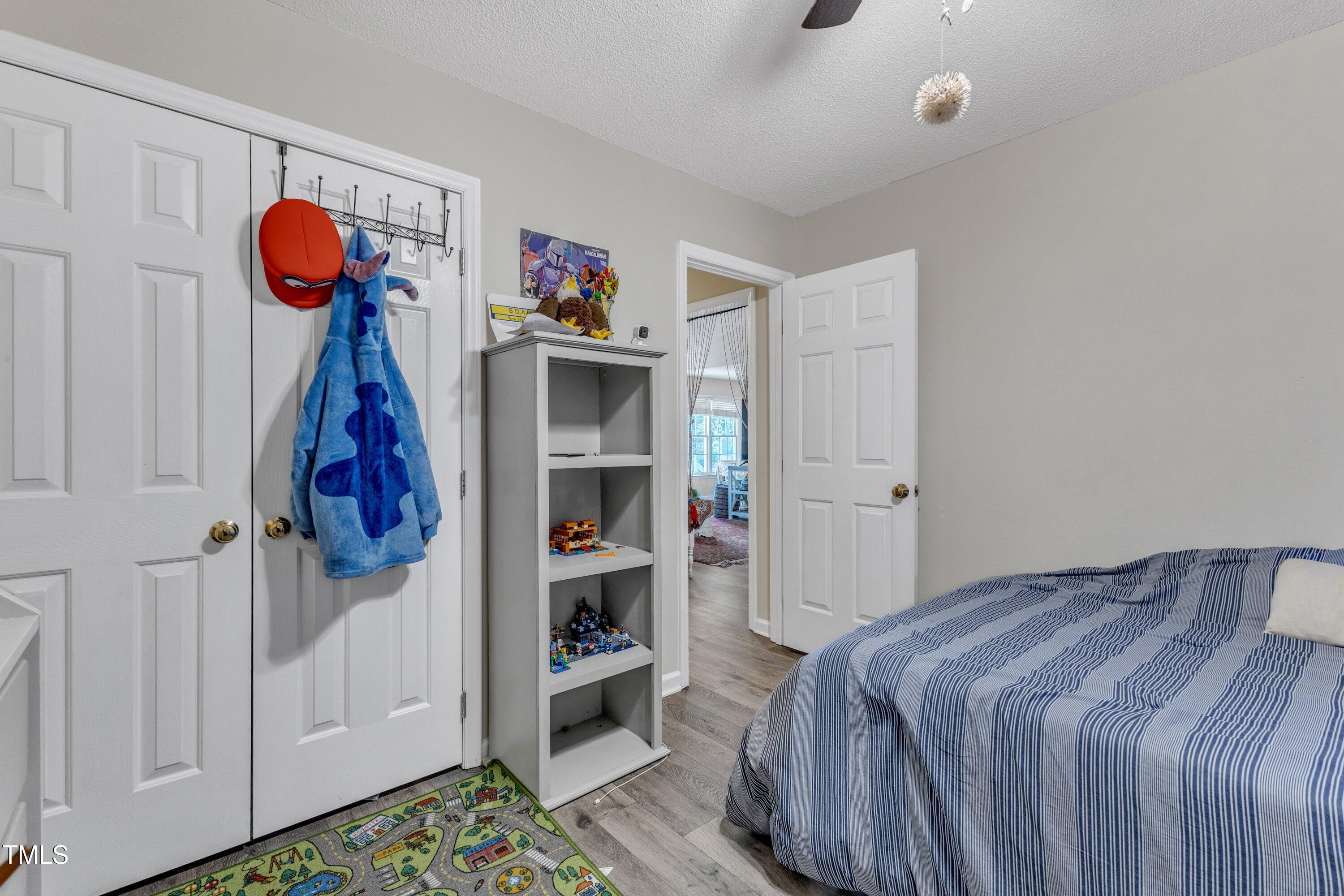 9512 Anson Grove Lane Raleigh, NC 27615 - Photo 28 of 39 a bedroom with a bed and a book shelf
