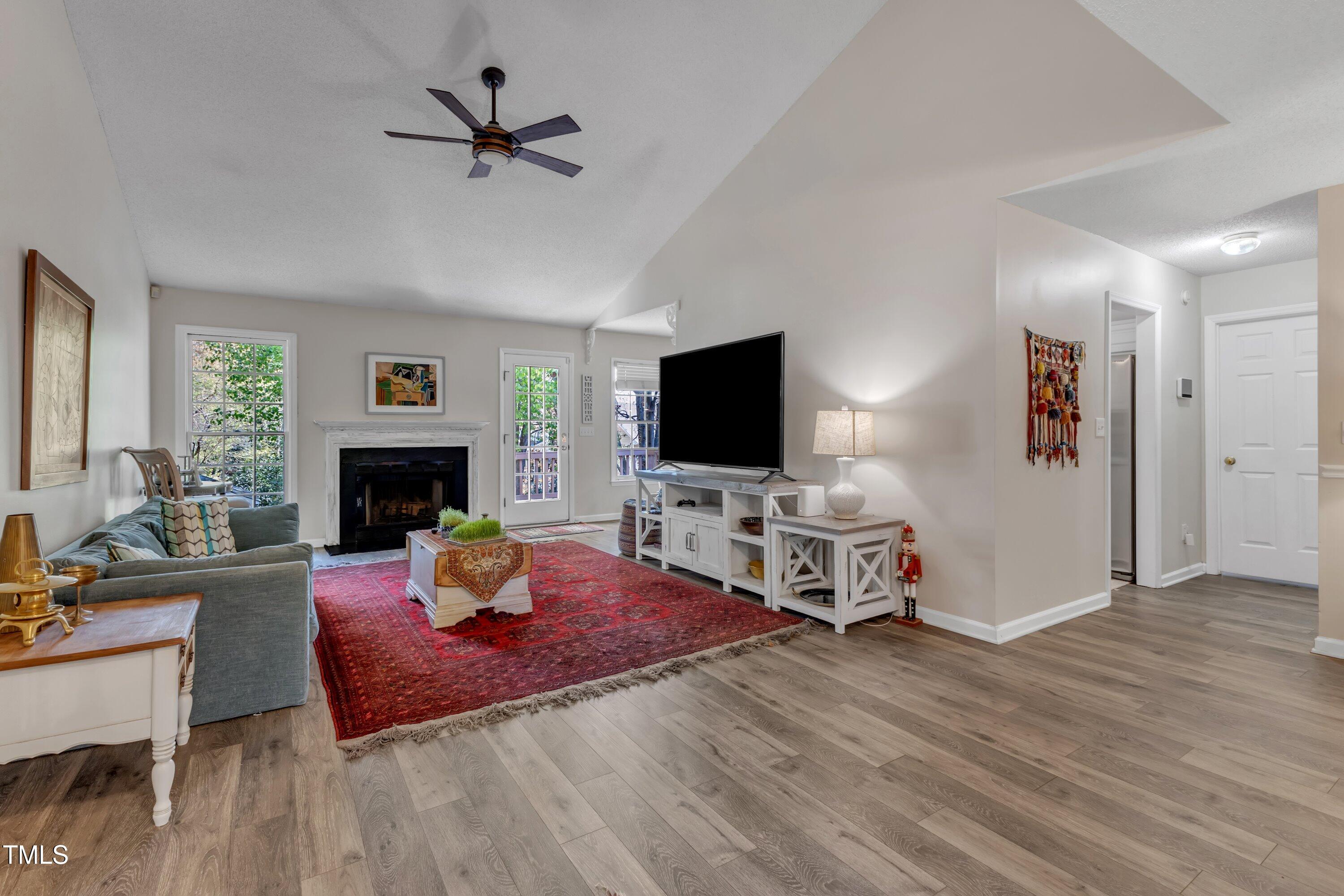 9512 Anson Grove Lane Raleigh, NC 27615 - Photo 4 of 39 a living room with furniture a flat screen tv and a fireplace