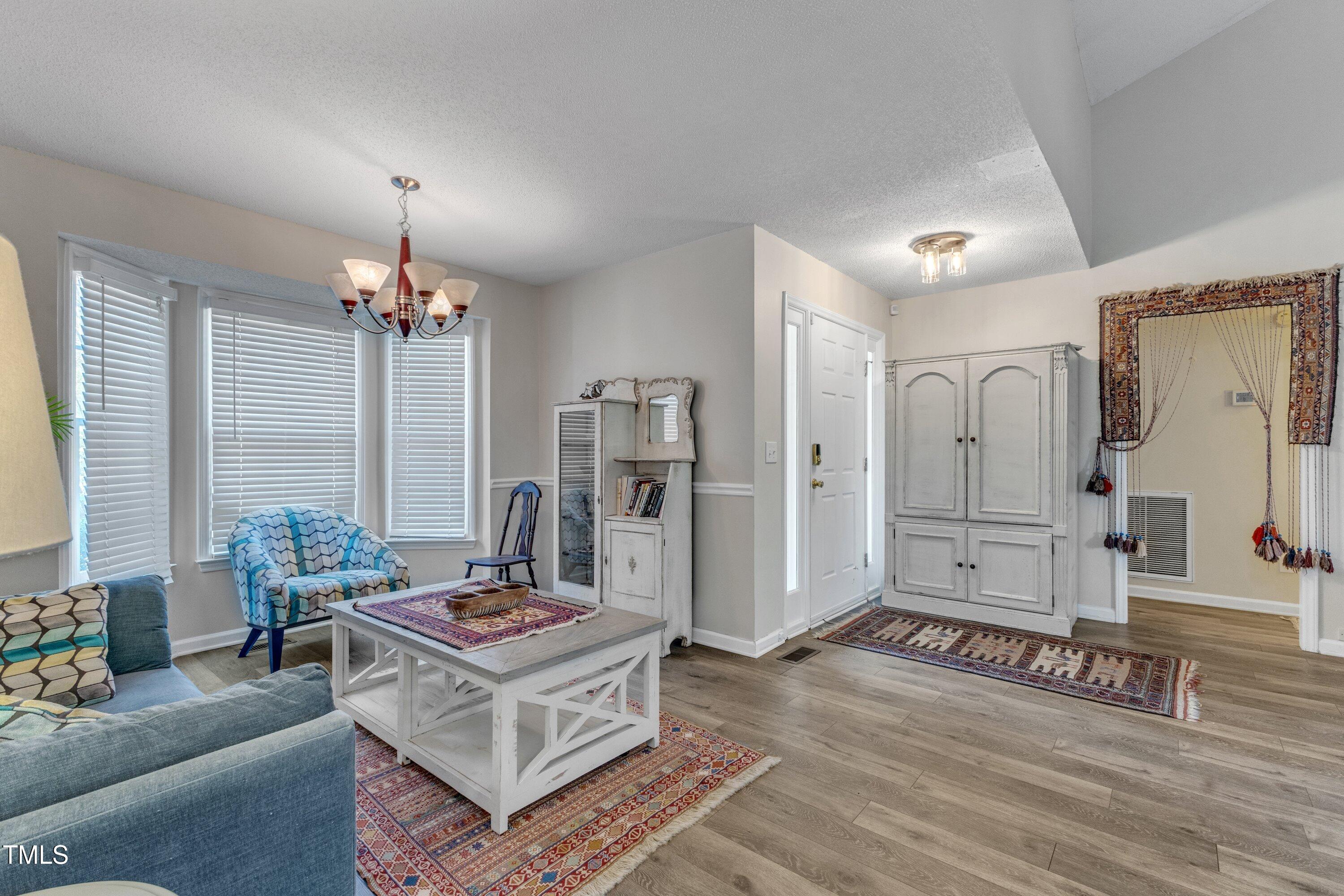 9512 Anson Grove Lane Raleigh, NC 27615 - Photo 10 of 39 a living room with furniture and a chandelier