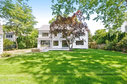 a yellow house with a tree in front of it