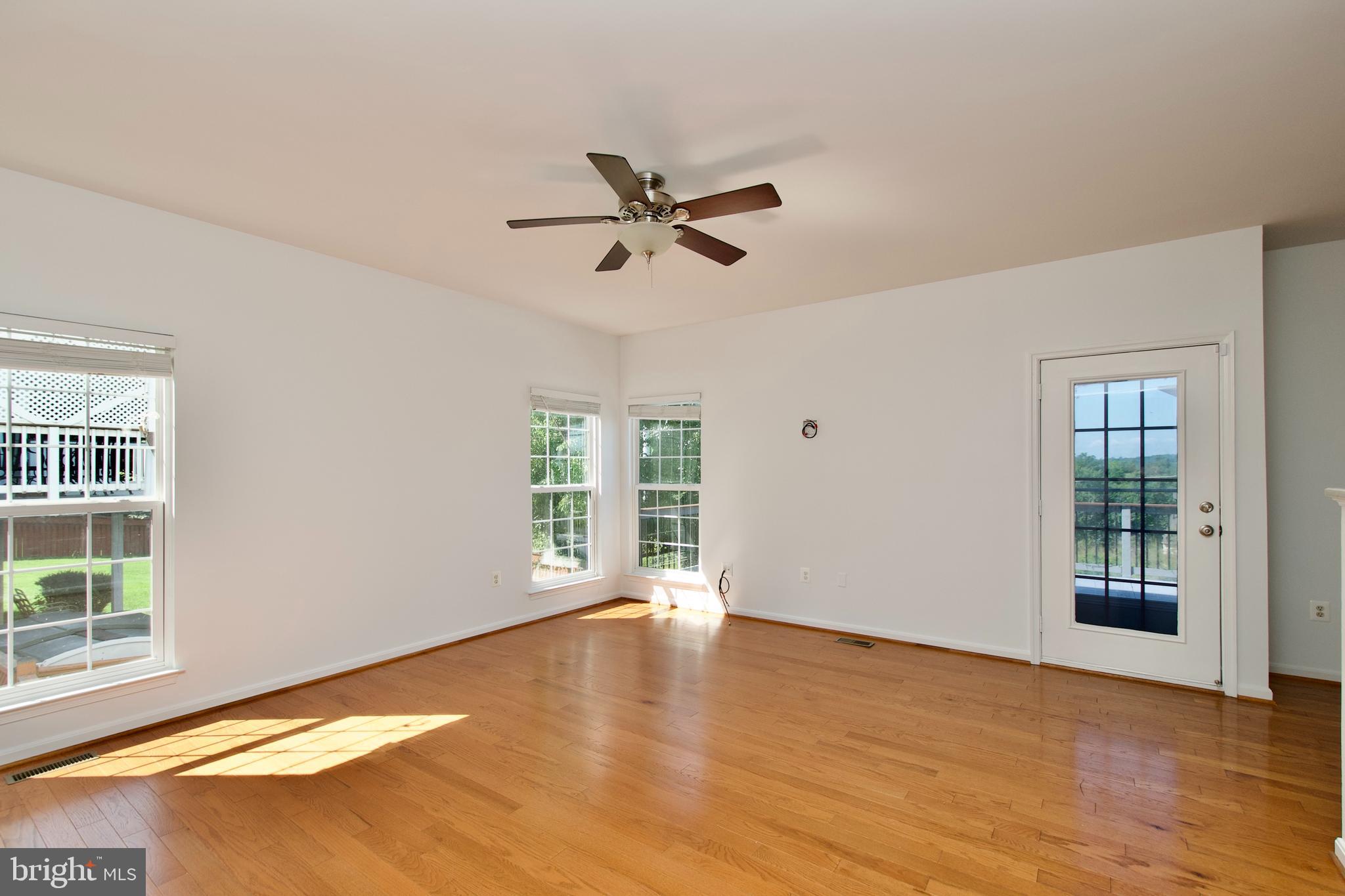 17528 October Glory Loop Dumfries, VA 22026 - Photo 17 of 50 an empty room with wooden floor fan and windows