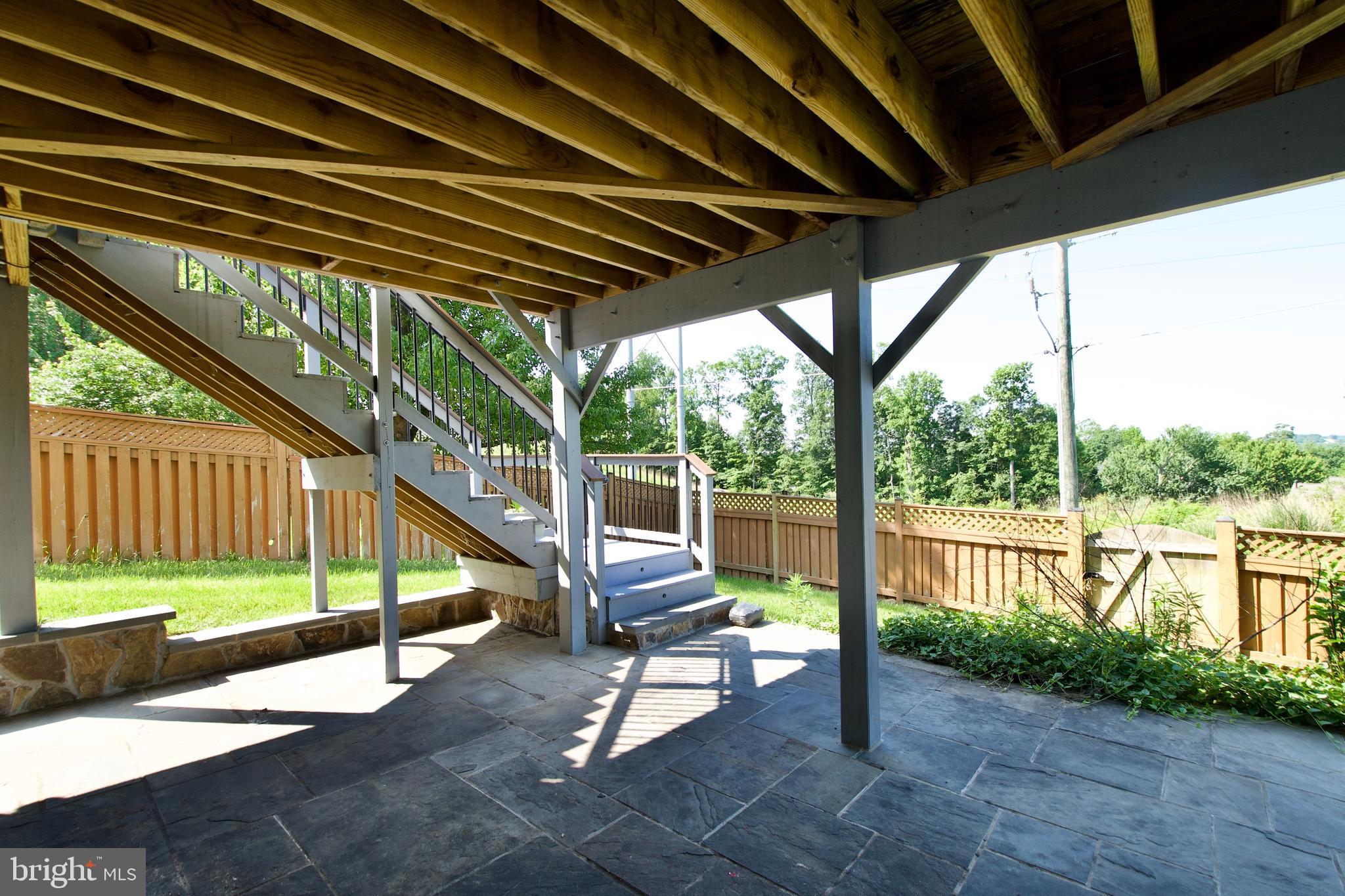 17528 October Glory Loop Dumfries, VA 22026 - Photo 42 of 50 a view of a deck with couches and wooden floor next to a yard