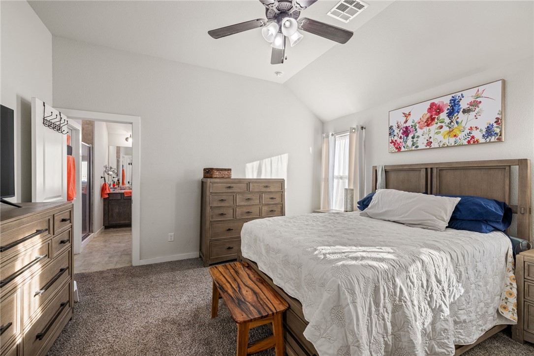 3417 Calmar Court Bryan, TX 77808 - Photo 17 of 31 Bedroom with vaulted ceiling, carpet floors, ceiling fan, and ensuite bathroom