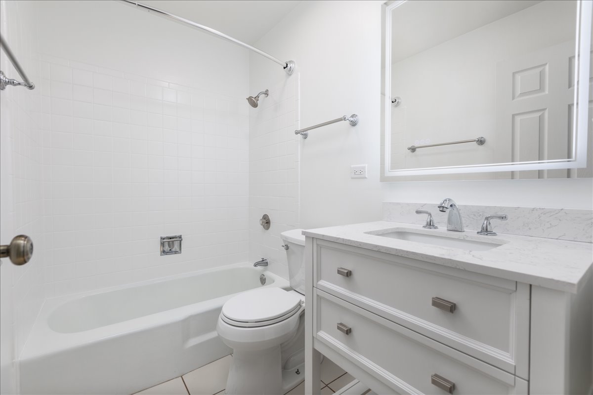 5740 East Avenue, Unit 2D Countryside, IL 60525 - Photo 12 of 24 a bathroom with a granite countertop sink a toilet and shower
