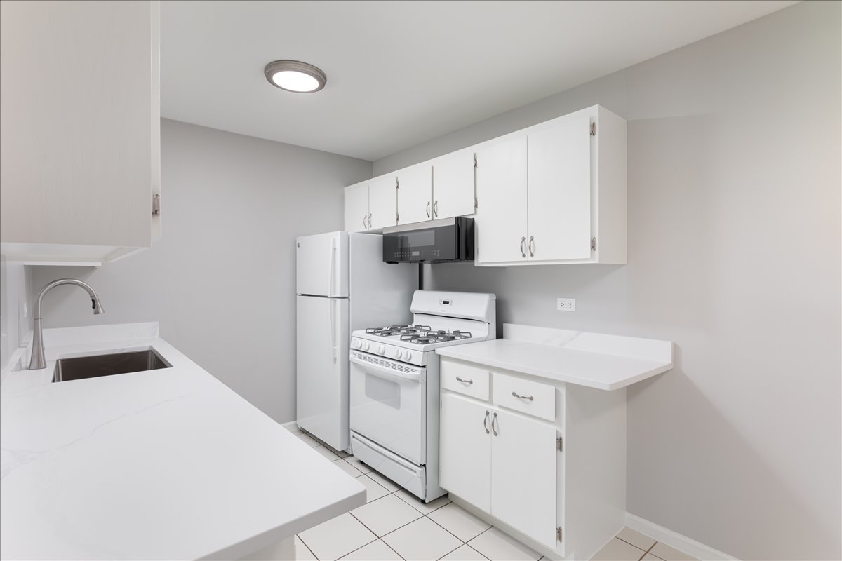 5740 East Avenue, Unit 2D Countryside, IL 60525 - Photo 4 of 24 a kitchen with a sink dishwasher stove and white cabinets