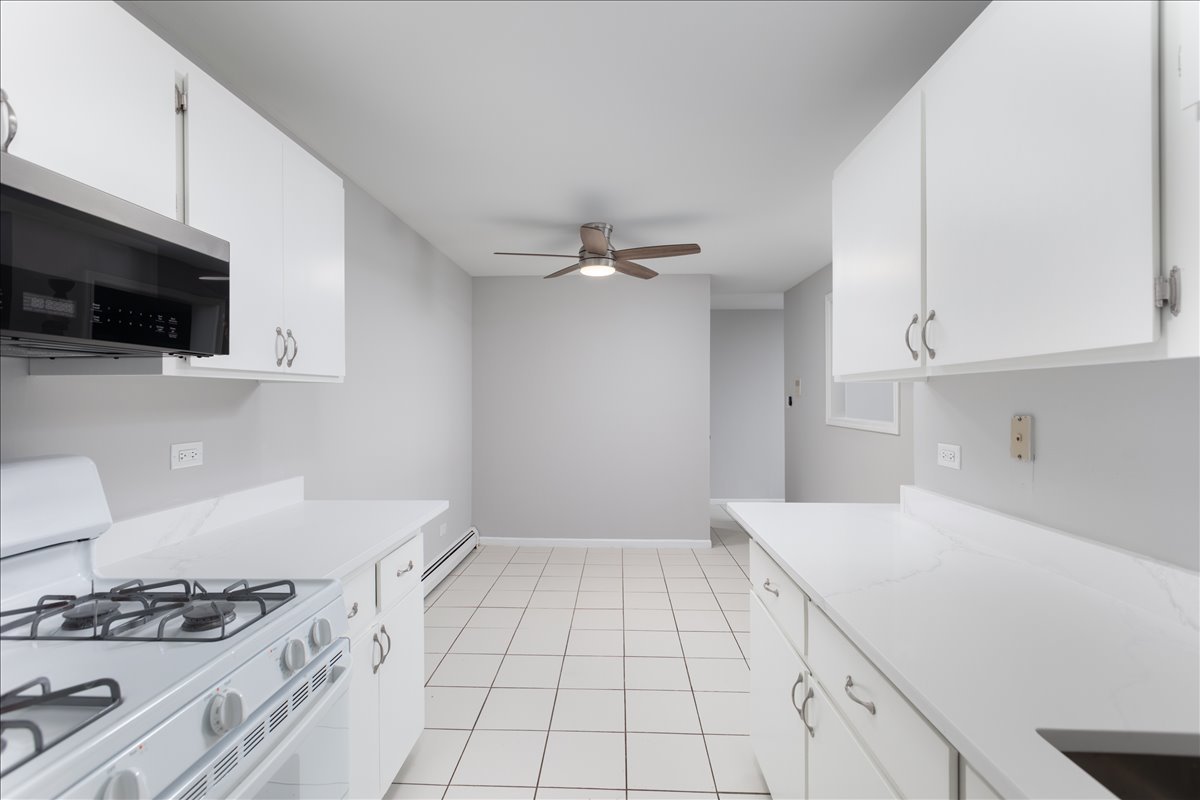 5740 East Avenue, Unit 2D Countryside, IL 60525 - Photo 5 of 24 a kitchen with a sink a stove and cabinets