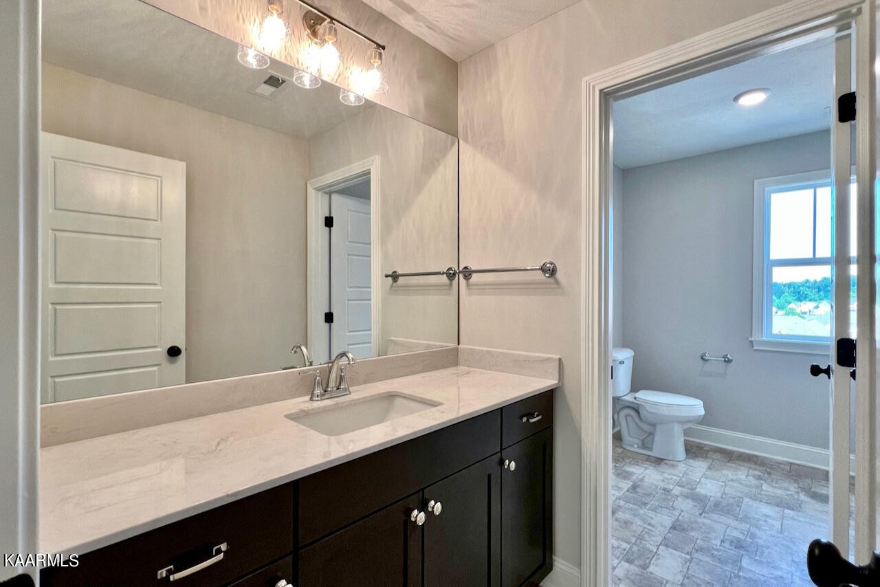 9356 Gabrielle Road Strawberry Plains, TN 37871 - Photo 31 of 39 a bathroom with a sink a toilet a large mirror and shower