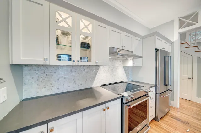 a bedroom with a bed a couch and a flat tv screen on dresser