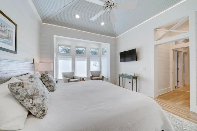 a view of a patio with couches table and chairs with wooden floor and fence