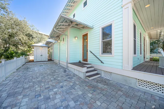 a kitchen with kitchen island a refrigerator a stove a sink dishwasher and white cabinets with wooden floor