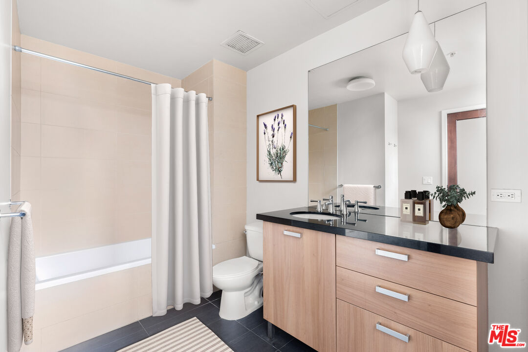 460 South Spring Street, Unit 507 Los Angeles, CA 90013 - Photo 12 of 25 a bathroom with a double vanity sink toilet mirror and bathtub