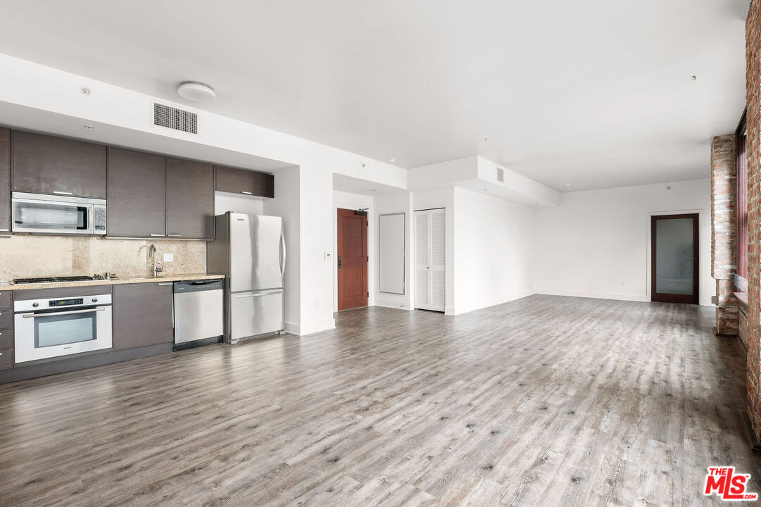 460 South Spring Street, Unit 507 Los Angeles, CA 90013 - Photo 7 of 25 a kitchen with stainless steel appliances granite countertop a refrigerator and a stove top oven