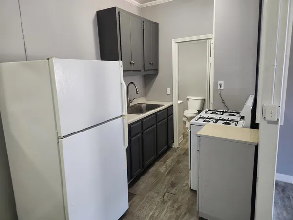 a white refrigerator freezer and a stove sitting inside of a kitchen
