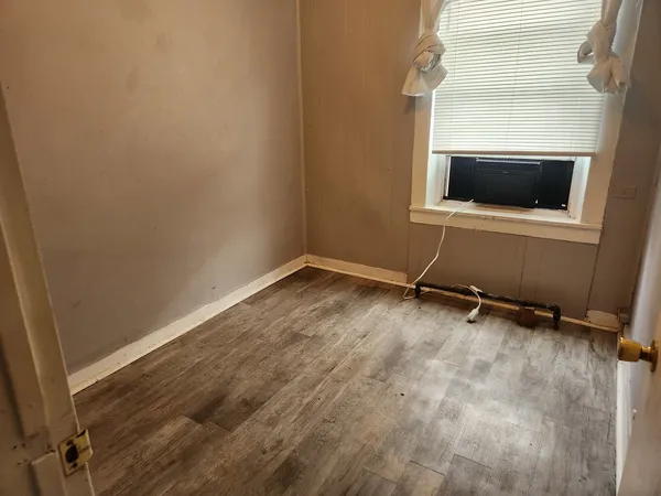 a view of a room with wooden floor and cabinet