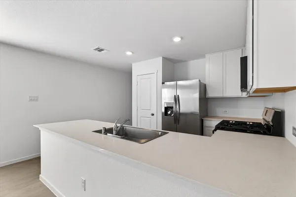 a kitchen with a sink and steel appliances