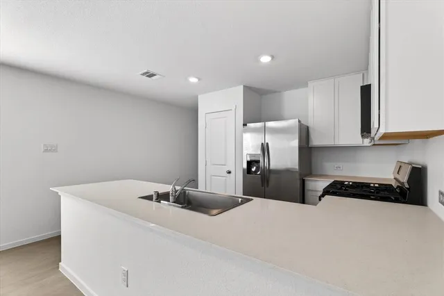 a kitchen with a sink and steel appliances