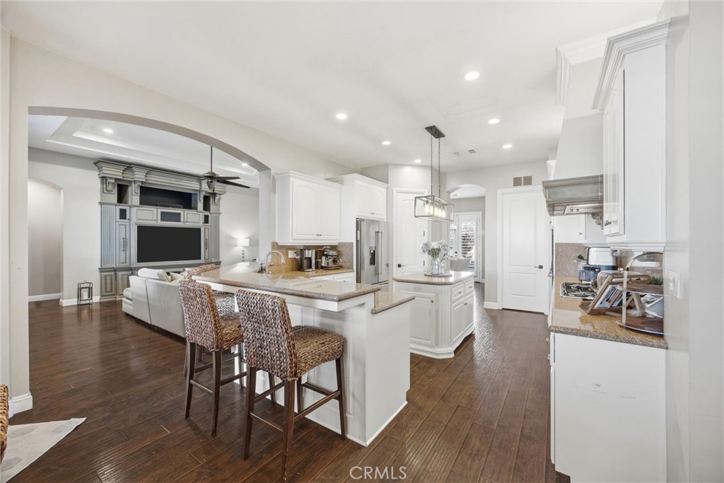 2103 Redmire Street Bakersfield, CA 93311 - Photo 20 of 53 a kitchen with a dining table chairs and wooden floor