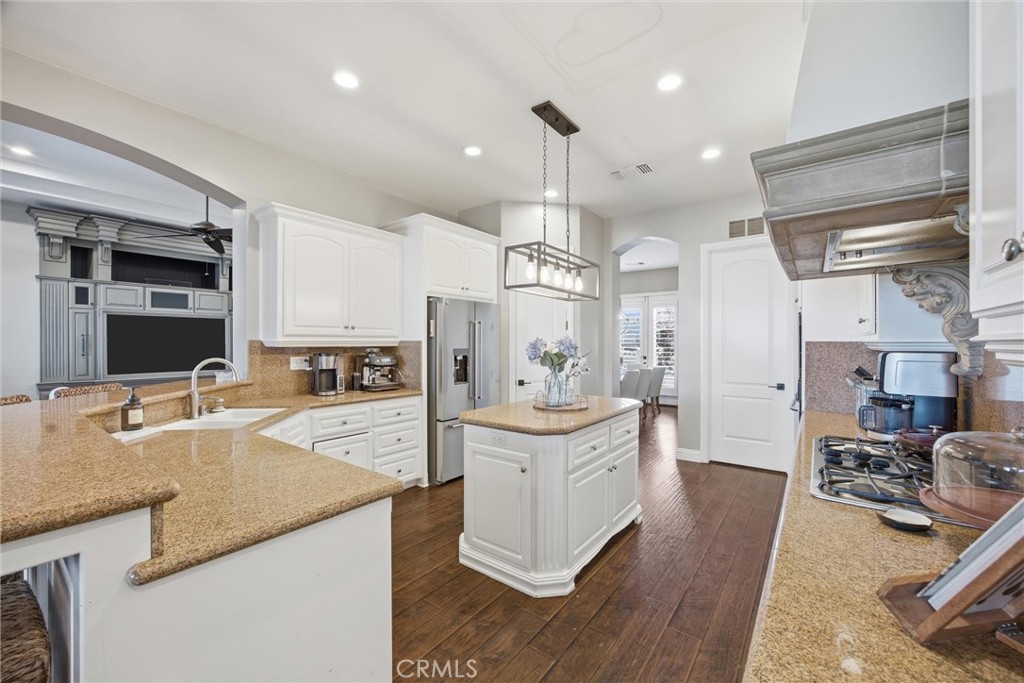 2103 Redmire Street Bakersfield, CA 93311 - Photo 22 of 53 a large kitchen with stainless steel appliances kitchen island granite countertop a sink and cabinets