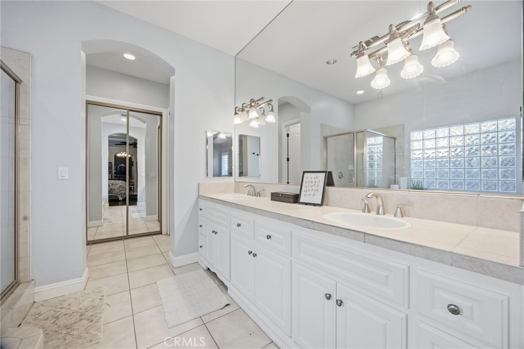 2103 Redmire Street Bakersfield, CA 93311 - Photo 30 of 53 a spacious bathroom with a granite countertop sink a mirror and a shower