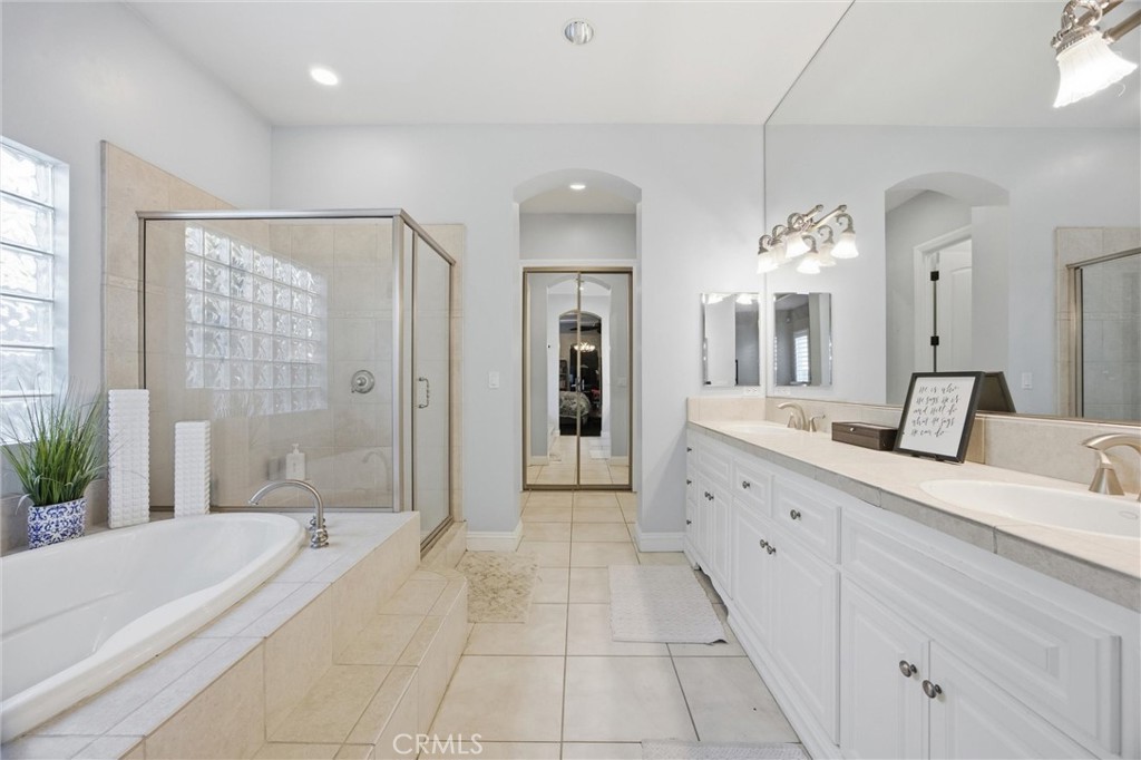 2103 Redmire Street Bakersfield, CA 93311 - Photo 31 of 53 a spacious bathroom with a granite countertop sink a mirror a shower and a bathtub