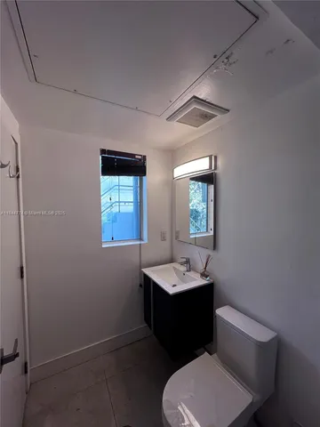 a bathroom with a toilet sink and mirror